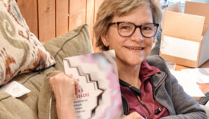 Kathy O’Shea holding her book, “So Much More Than a Headache: Understanding Migraine through Literature.”